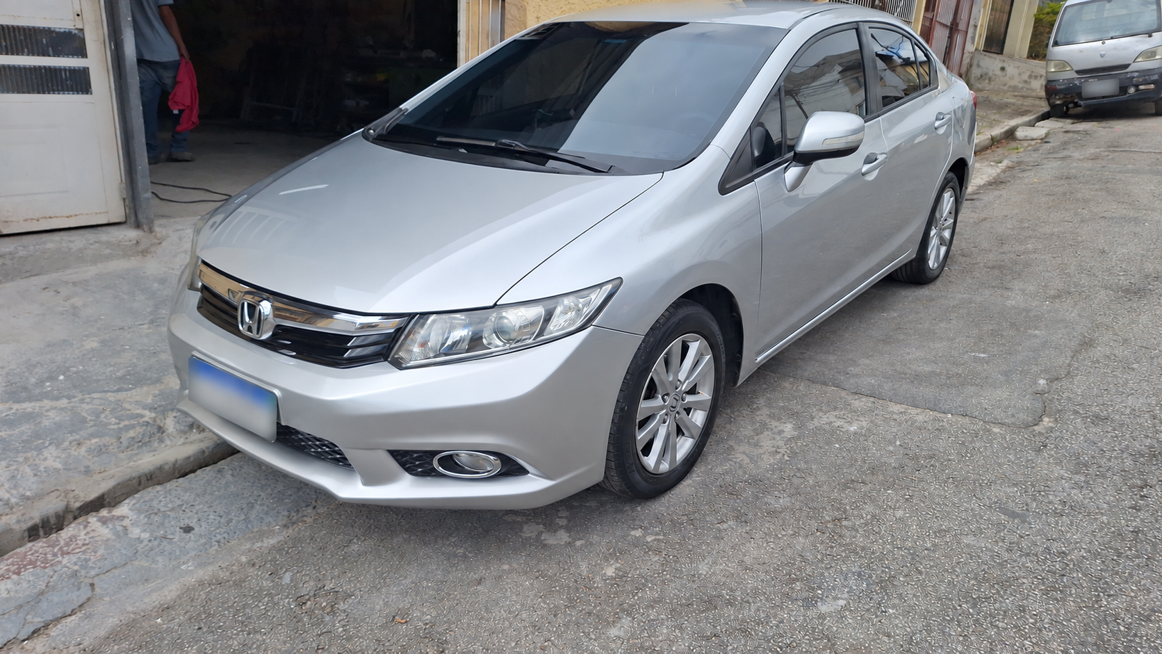 Honda Civic prata visto de frente pelo lado do passageiro, com pintura impecável
