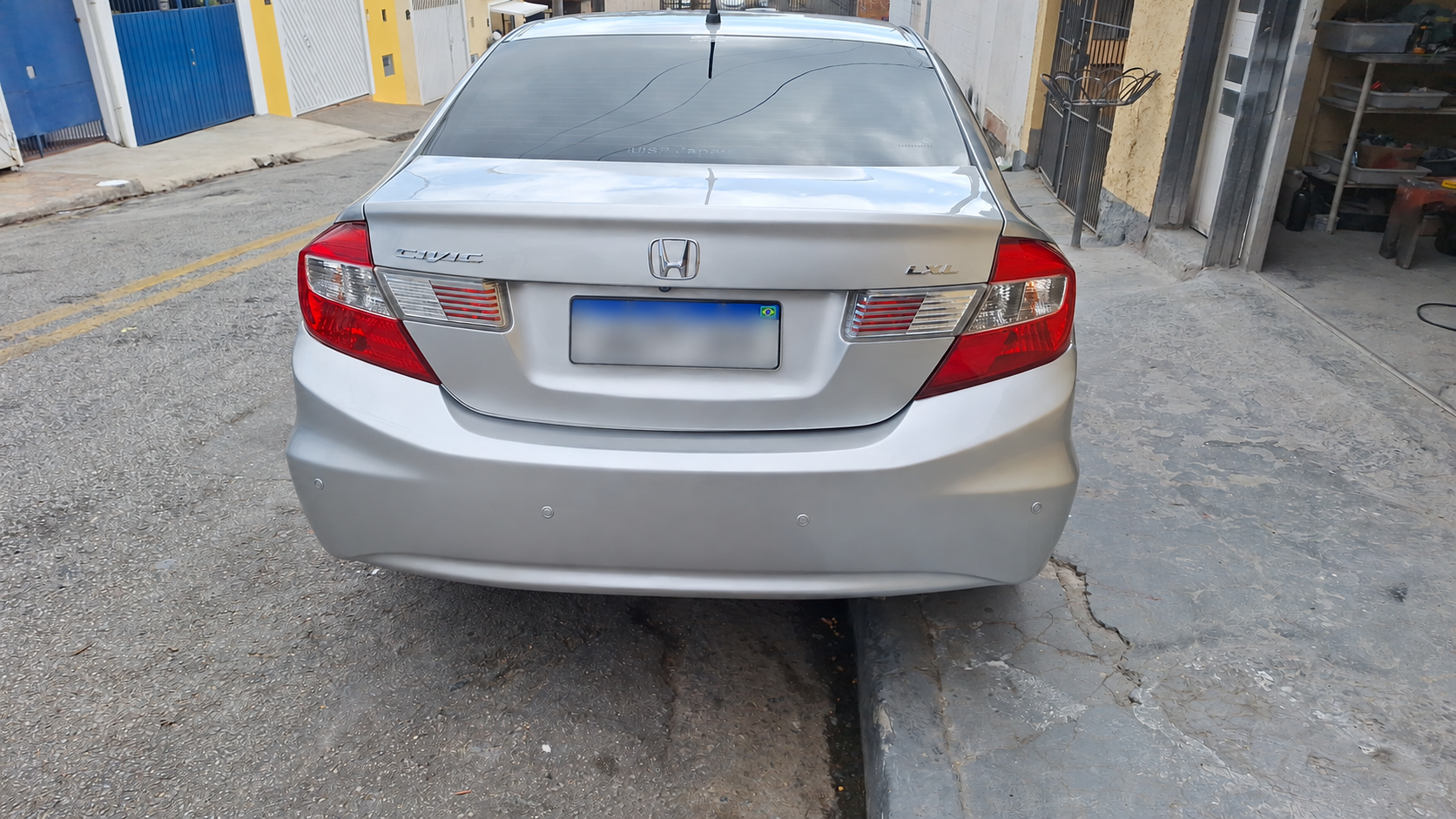 Honda Civic prata visto diretamente de trás, com acabamento brilhante